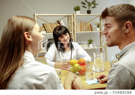 Smiling nutritionist showing a healthy diet plan to patient 55989288