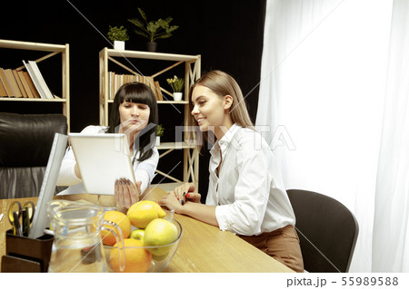 Smiling nutritionist showing a healthy diet plan to patient Smiling nutritionist showing a healthy diet plan to patient 55989588