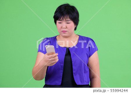 Young beautiful overweight Asian woman using phone Young beautiful overweight Asian woman using phone 55994244