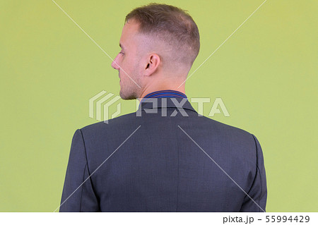 Closeup rear view of businessman in suit looking over shoulder 55994429
