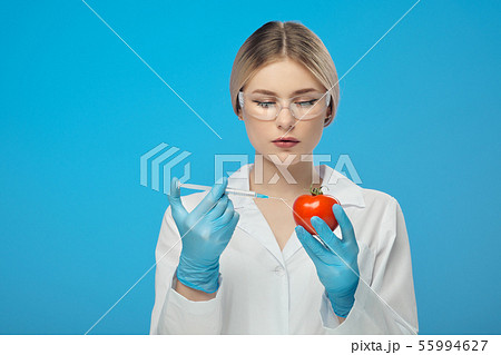 A woman biologist scientist in the lab, in a white coat, and rubber gloves on a blue background 55994627