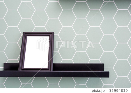 Blank picture frame on a shelf with blue and white color wallpaper background, retro design Blank picture frame on a shelf with blue and white color wallpaper background, retro design 55994839