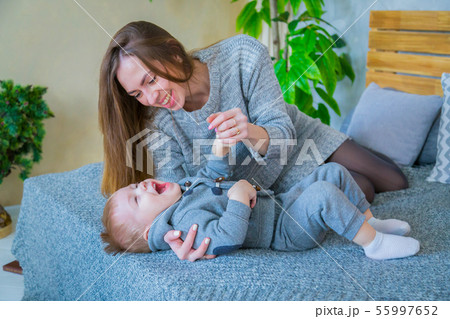 Happy young mother and her baby son playing togerher Happy young mother and her baby son playing togerher 55997652