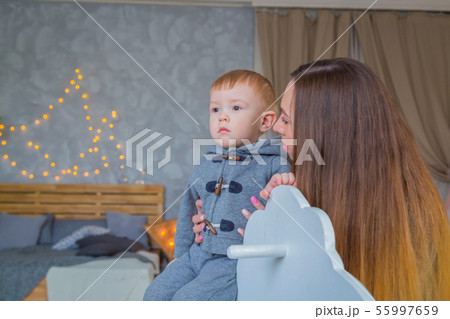 Portrait of little boy on wooden rocking horse 55997659