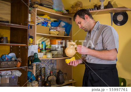 Potter preparing ceramic wares for burning Potter preparing ceramic wares for burning 55997761