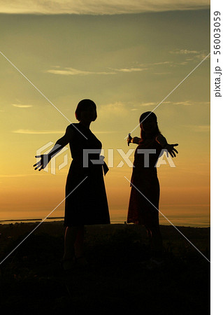 夕焼け空と女性たちのシルエット 夕焼け空と女性たちのシルエット 56003059