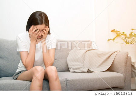 Severe migraine headache holding hands to head. 56013313