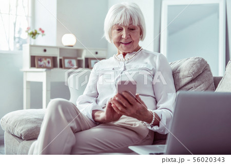 Elegant stylish grandmother typing message to her grandchildren 56020343