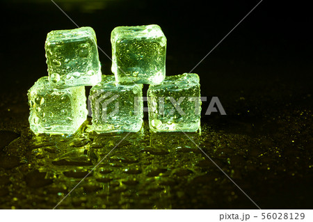 Green ice cubes on black table background. Green ice cubes on black table background. 56028129