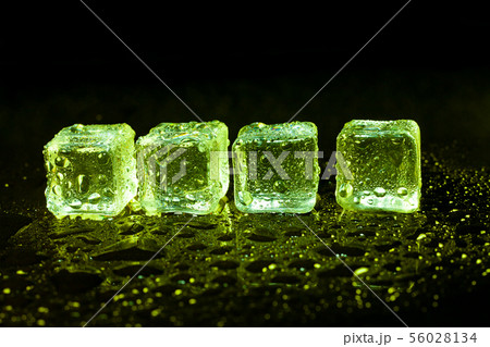 Green ice cubes on black table background. Green ice cubes on black table background. 56028134