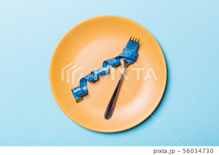 Top view of fork with measure tape in round plate Top view of fork with measure tape in round plate 56034730