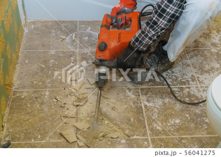 Worker remove, demolish old tiles in a bathroom Worker remove, demolish old tiles in a bathroom 56041275