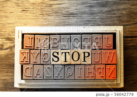 木目の上に置いたハンコ STOP の文字と木目の背景 木目の上に置いたハンコ STOP の文字と木目の背景 56042779