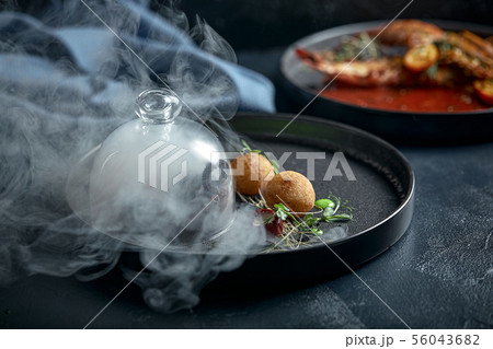 Grilled grilled octopus served with smoke under the hood, food show, low key. Copy space, food 56043682