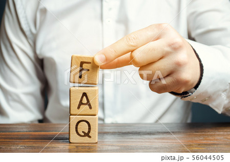 Businessman puts wooden blocks with the word FAQ Businessman puts wooden blocks with the word FAQ 56044505