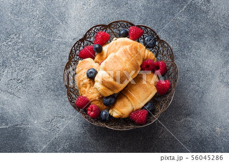 Croissants with fresh raspberries and blueberries  56045286