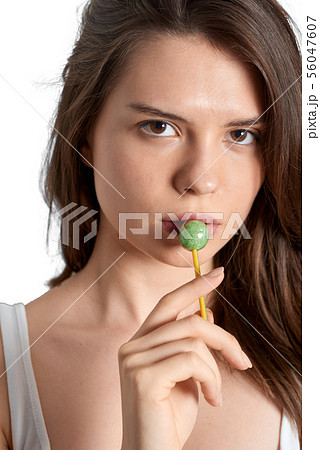 Young girl sucking lollipop and looking at the 56047607
