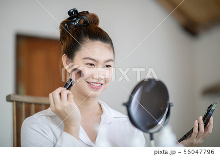 woman brunette cosmetics using make up brush woman brunette cosmetics using make up brush 56047796