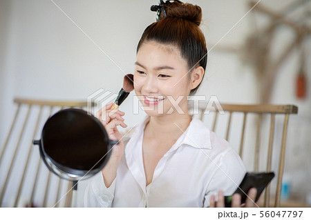 woman brunette cosmetics using make up brush 56047797