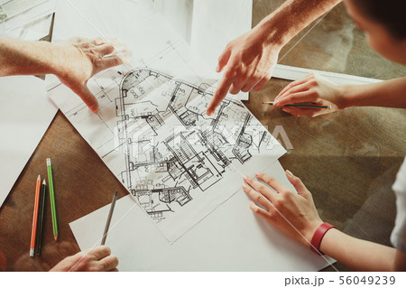Foreman or achitect shows house, office or store design plans to a young couple 56049239