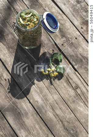Jar with Linden blossom on wooden table. 56049415
