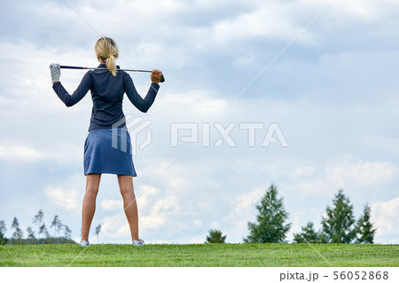 Goal concept, copy space. Women golfing time holding golf equipment on green field background. The 56052868
