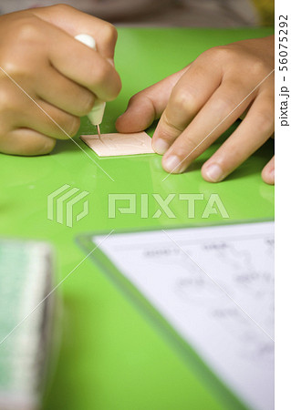 祭りでカタヌキをする子供手元 56075292