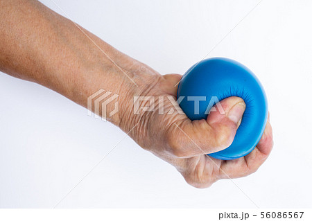 Senior woman's hand squeezing blue stress ball 56086567