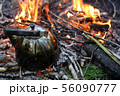 old shiny metal kettle basks on a fire, travel 56090777