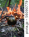 old shiny metal kettle basks on a fire, travel 56090779