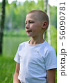 teenager boy in a white T-shirt walks in the woods 56090781