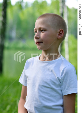 teenager boy in a white T-shirt walks in the woods teenager boy in a white T-shirt walks in the woods 56090781