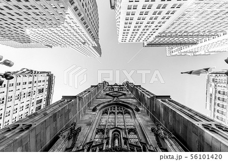 Wide angle upward view of Trinity Church at Broadway and Wall Street with surrounding skyscrapers Wide angle upward view of Trinity Church at Broadway and Wall Street with surrounding skyscrapers 56101420