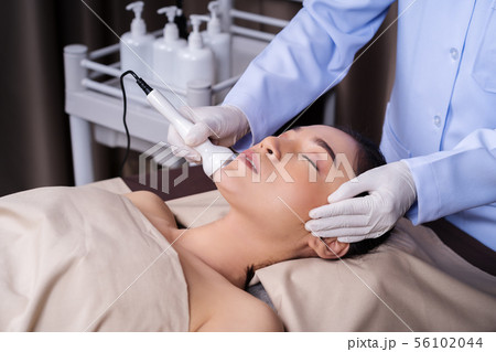 woman receiving ultrasound facial beauty treatment 56102044