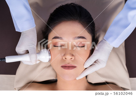 woman receiving ultrasound facial beauty treatment 56102046