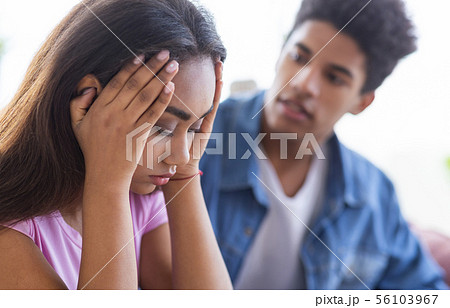 Black teen guy comforting his upset female friend 56103967