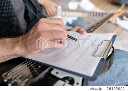 Older brother explains to his younger one how to use notes on music sheets on an exapmple 56105002