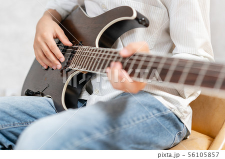 Electric guitar laying in hands of european male in casual clothes Electric guitar laying in hands of european male in casual clothes 56105857
