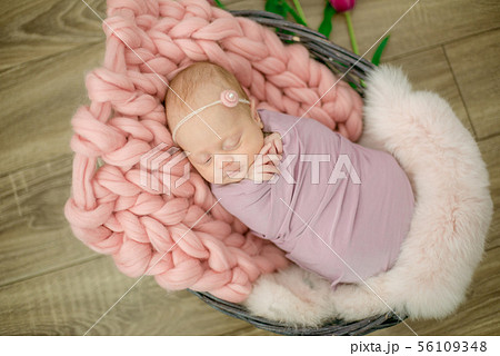 newborn baby girl in pink blanket in a basket newborn baby girl in pink blanket in a basket 56109348
