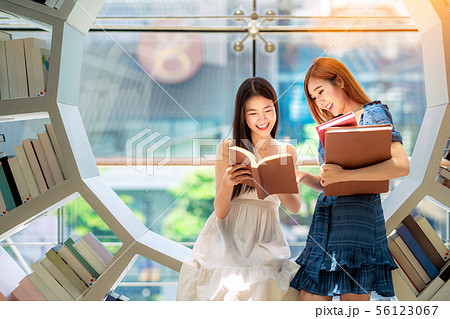 Asian girl student read a text book in library in 56123067