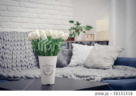 Vase with white tulips and couch 56131318