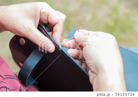 sewing the edge of a leather bag 56133734