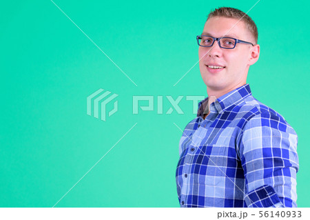 Closeup profile view of happy young hipster man looking at camera Closeup profile view of happy young hipster man looking at camera 56140933