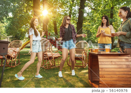 Happy friends are having beer and barbecue party at sunny day 56140976