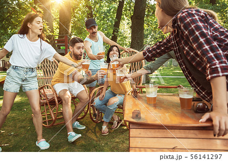 Happy friends are having beer and barbecue party at sunny day 56141297