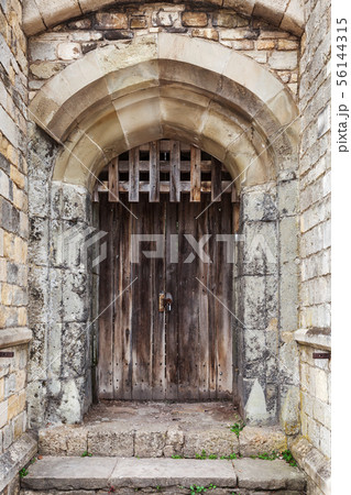 Locked wooden door in old fortification wall 56144315