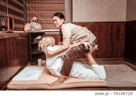 Masseuse helping her client straightening her back. 56188728