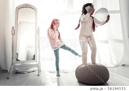Two sisters playing on the bedroom floor in the morning 56194555
