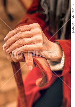 Close up of hands of an elderly woman leaning on cane 56196407