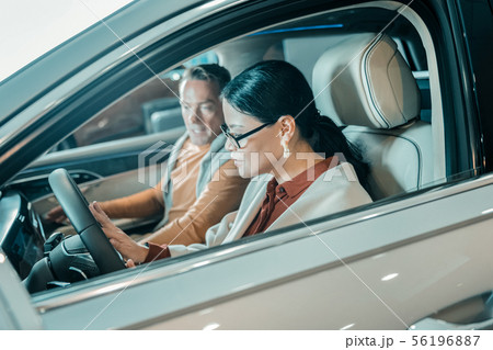 Woman sitting at the wheel of a new car. 56196887